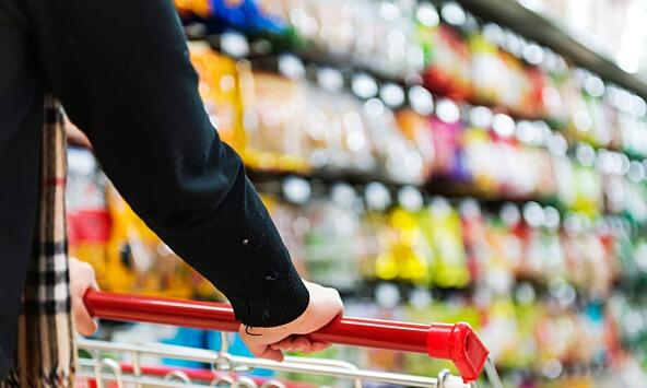 Supermarket trolley in front of shelves of produce